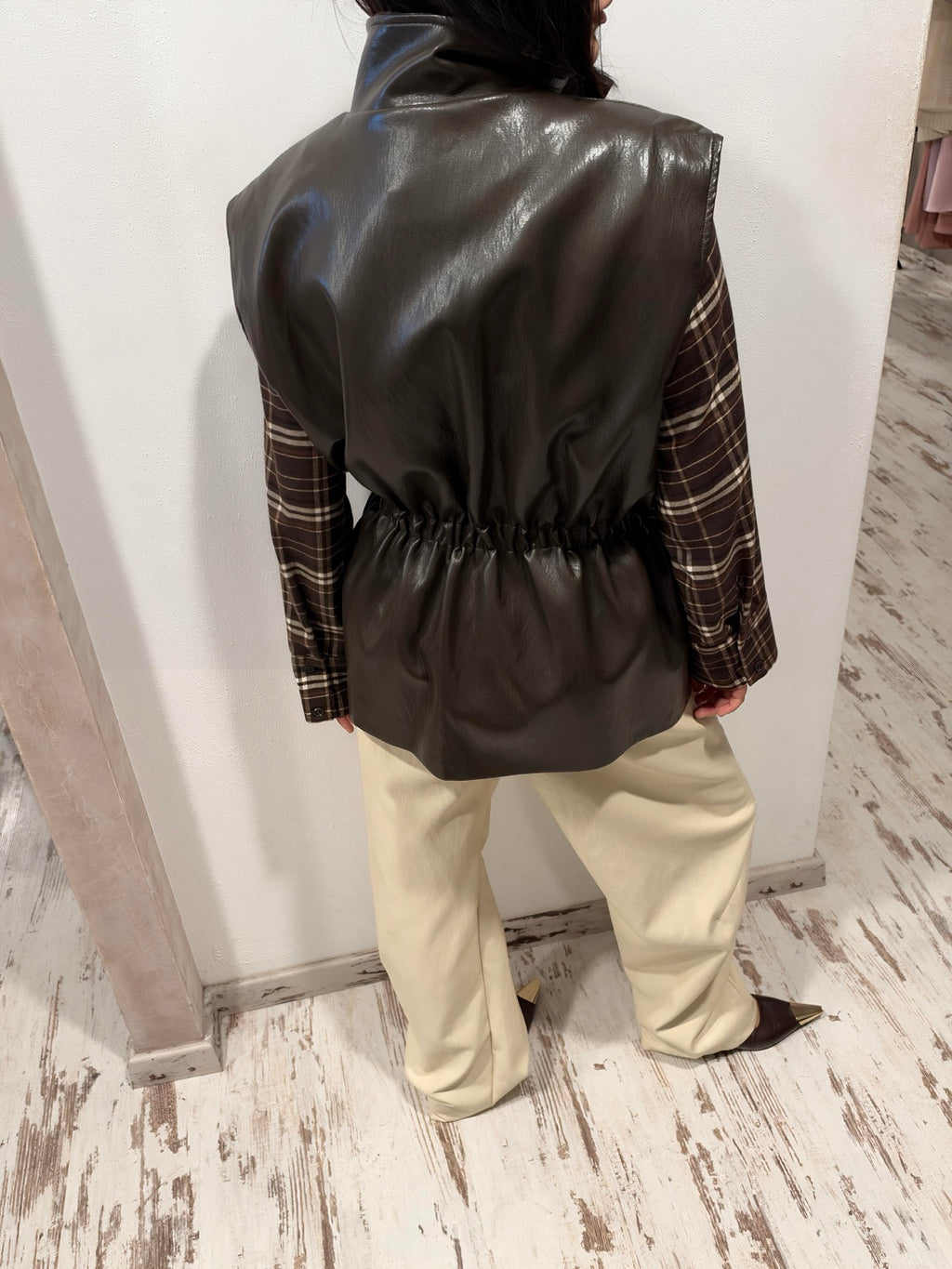 Gilet HaveOne in ecopelle scura, visto da dietro, con vita arricciata