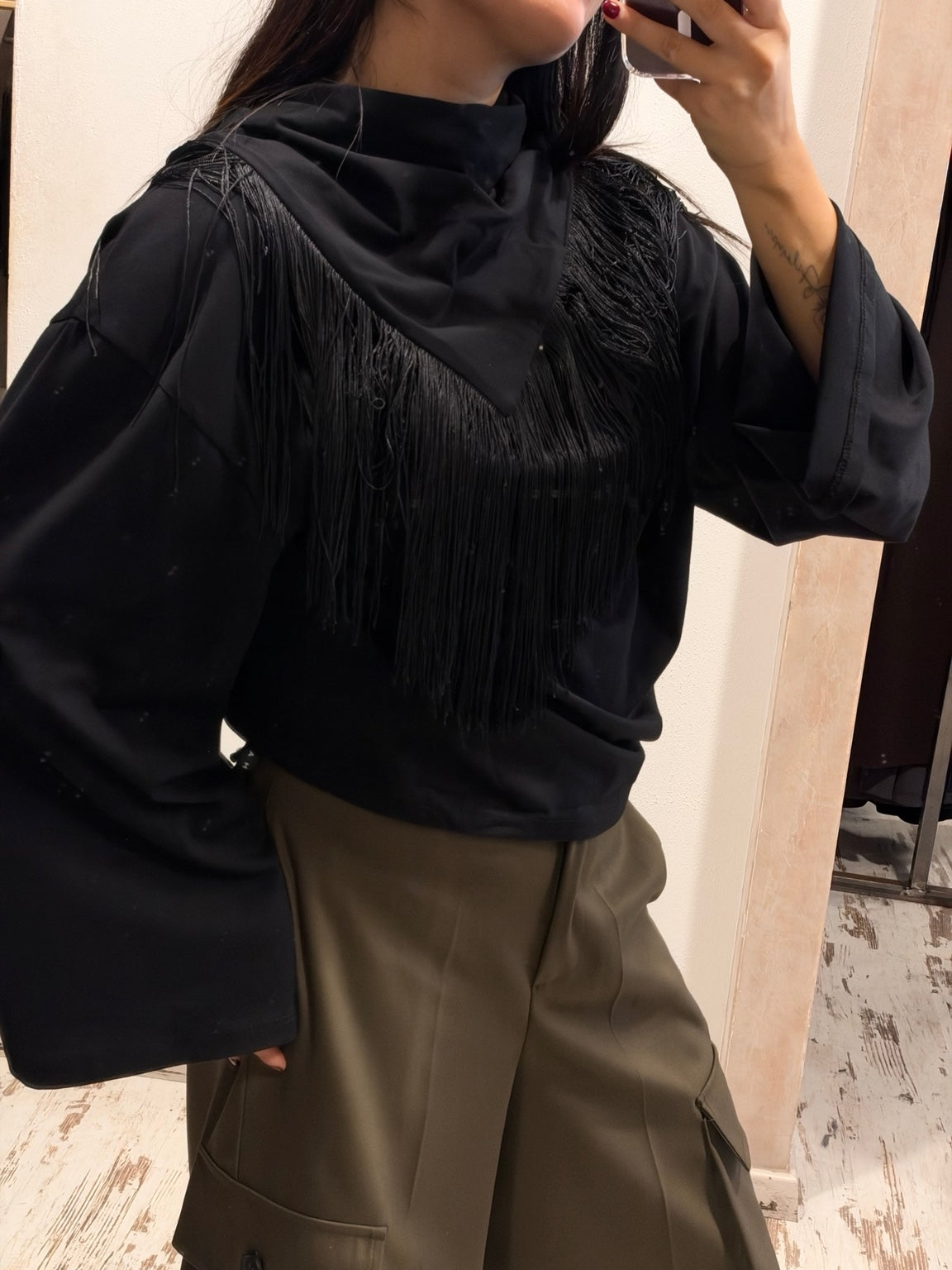 T-shirt nera con frange sul petto e scollo alto, maniche lunghe