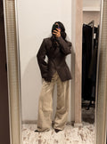 Blazer da donna scuro con revers a lancia e doppi bottoni, tasche a filetto.