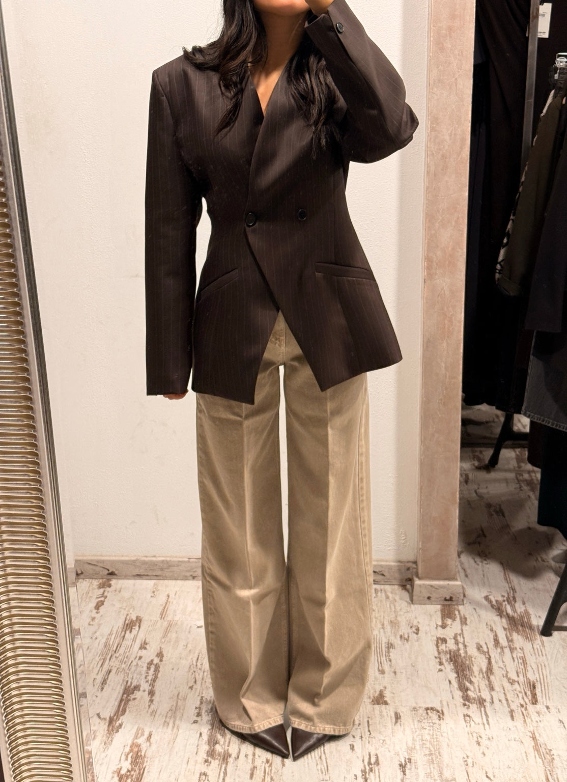 Blazer scuro con revers classico, chiusura con bottoni e tasche laterali.