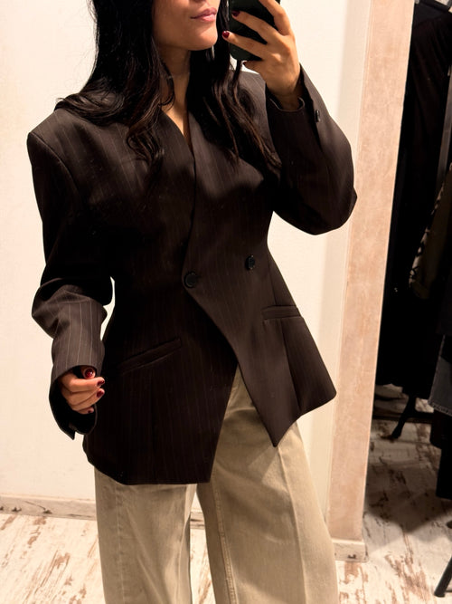 Blazer scuro con bottoni, tasca sul petto e tasche frontali, maniche lunghe.