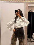 Camicia bianca con balze sulle spalle e maniche ampie, bottoni frontali