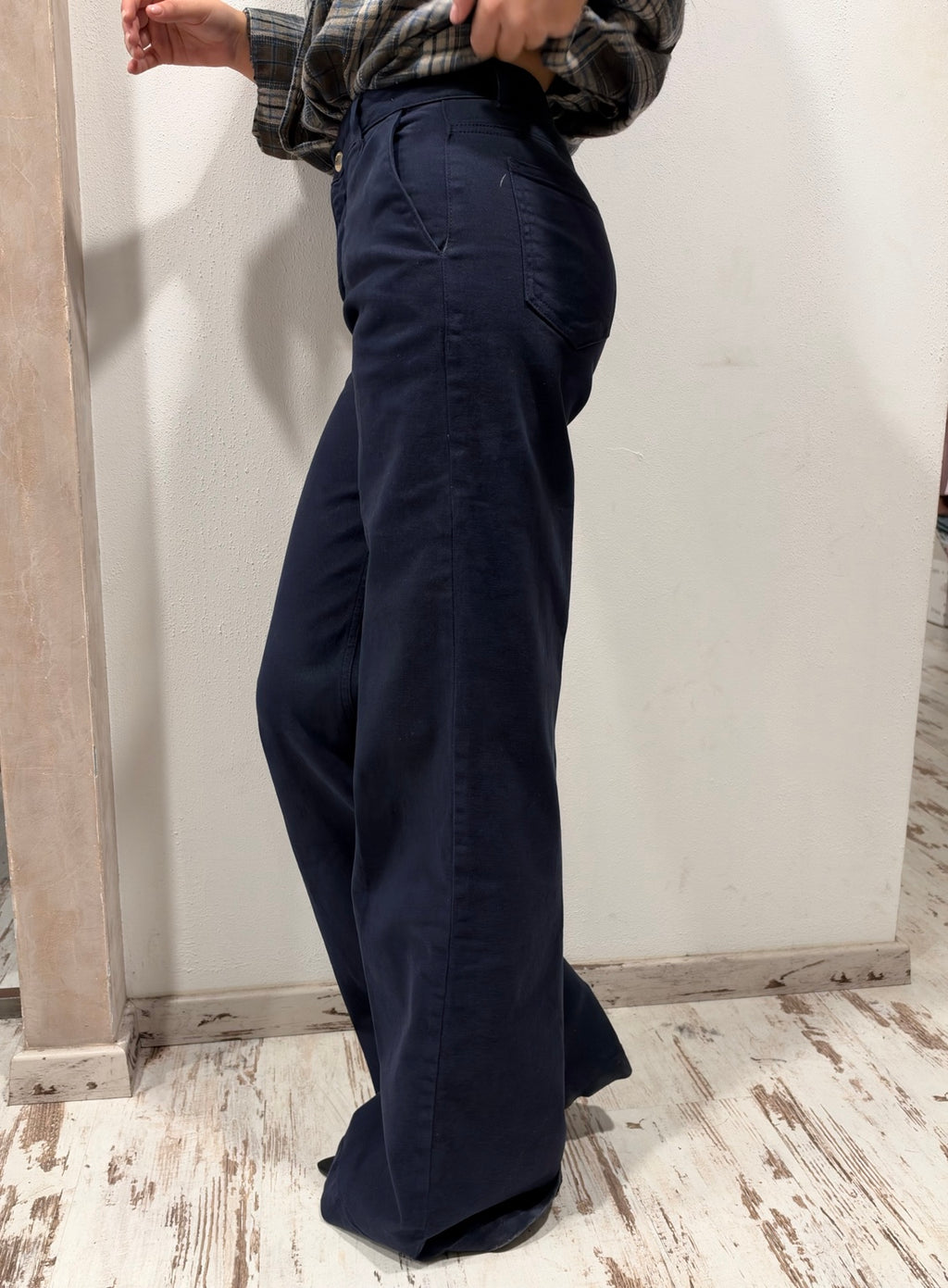 Jeans blu scuro a gamba ampia con cuciture verticali sul lato, dettagli in vita con bottoni