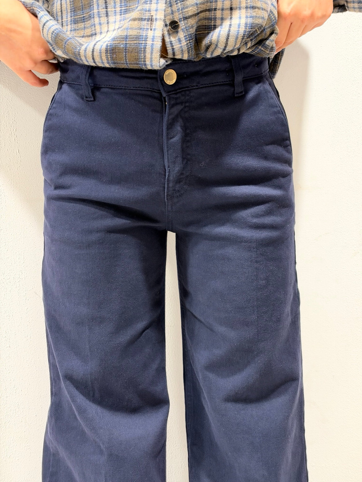 Pantaloni in denim blu scuro, chiusura con bottone, patta frontale e cuciture a contrasto
