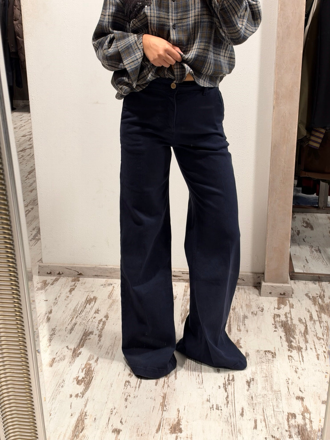Pantaloni in denim blu scuro a gamba larga, vita con bottone e tasche laterali visibili
